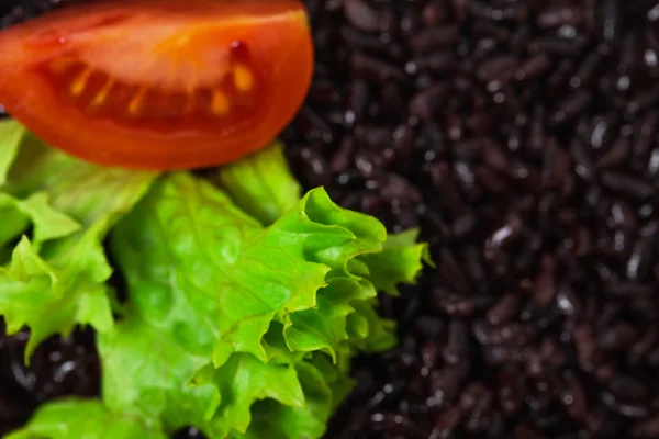 Risotto mit schwarzem Reis und Tomaten und Salat — Stockfoto