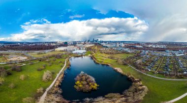 Baharda Avrupa finans merkezi Frankfurt 'ta 360 Panorama manzaralı güzel bir gökdelendir. Mavi gökyüzü, bulutlar, parkta göl, yeşil, renkli ağaçlar. Hesse, Almanya.