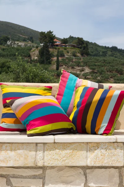Stone garden bench with colorful pillows — Stock Photo, Image