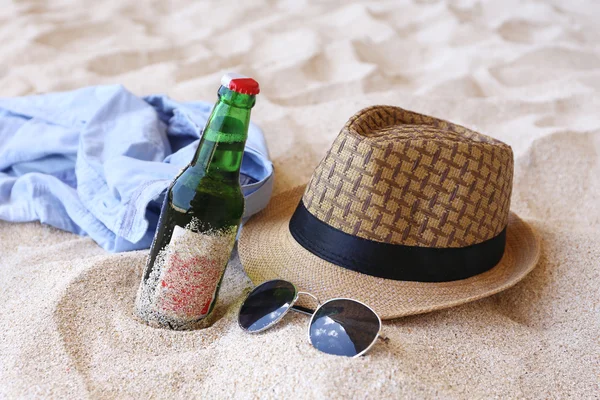 Butelek piwa, kapelusz, Okulary przeciwsłoneczne na plaży — Zdjęcie stockowe