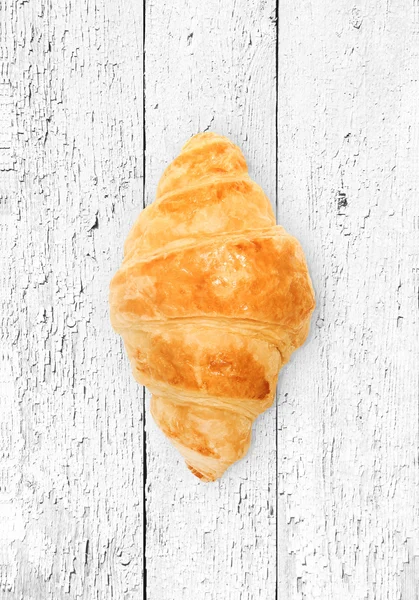 Croissant op een witte houten achtergrond — Stockfoto