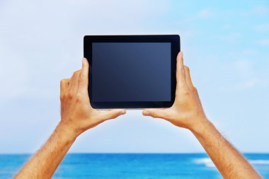 bir tablet tutan eller