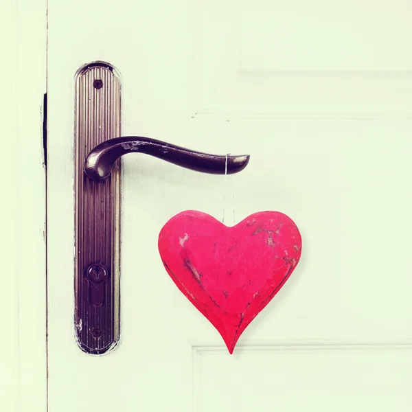 Red heart hanging on the door handle. vintage effect — Stock Photo, Image