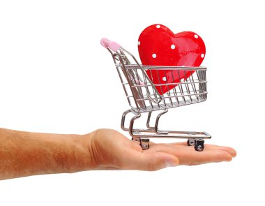 Beyaz zemin üzerinde bir alışveriş arabası içinde kırmızı kalp