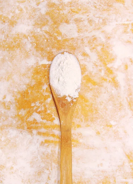 Wooden spoon with flour on derevyannm background — Stock Photo, Image