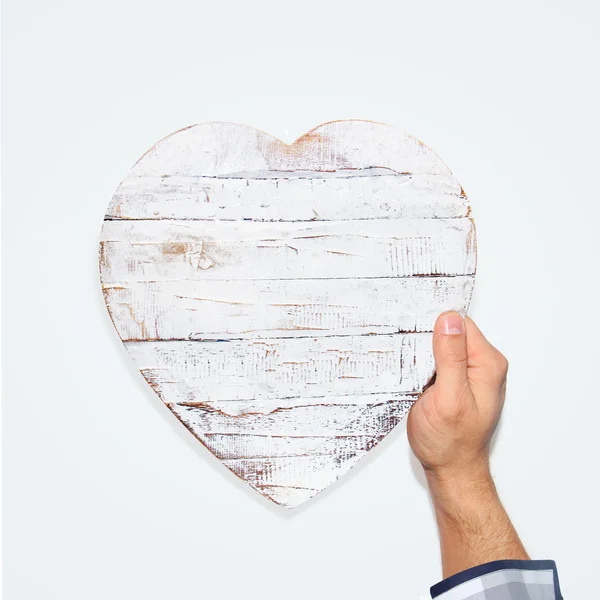 Mannelijke hand met een houten hart — Stockfoto