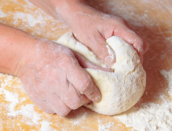 Le mani di donna anziana impastano la pasta Fotografia Stock