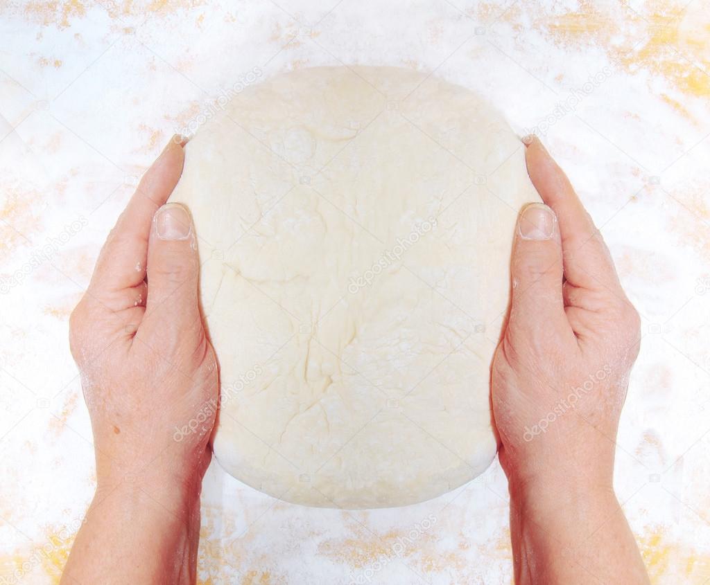 Women's hands knead the dough