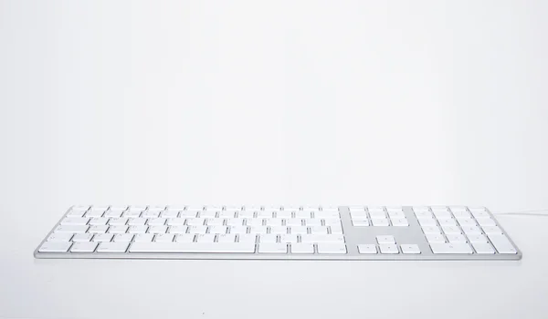 Gri bir arka plan üzerinde beyaz modern klavye — Stok fotoğraf