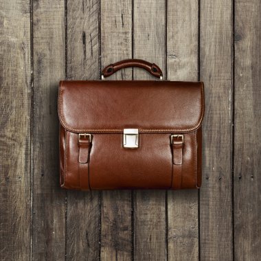 Briefcase on a wooden shabby background clipart