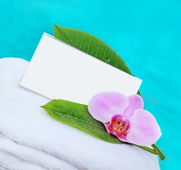 Карточка и цветок на белом полотенце — стоковое фото
