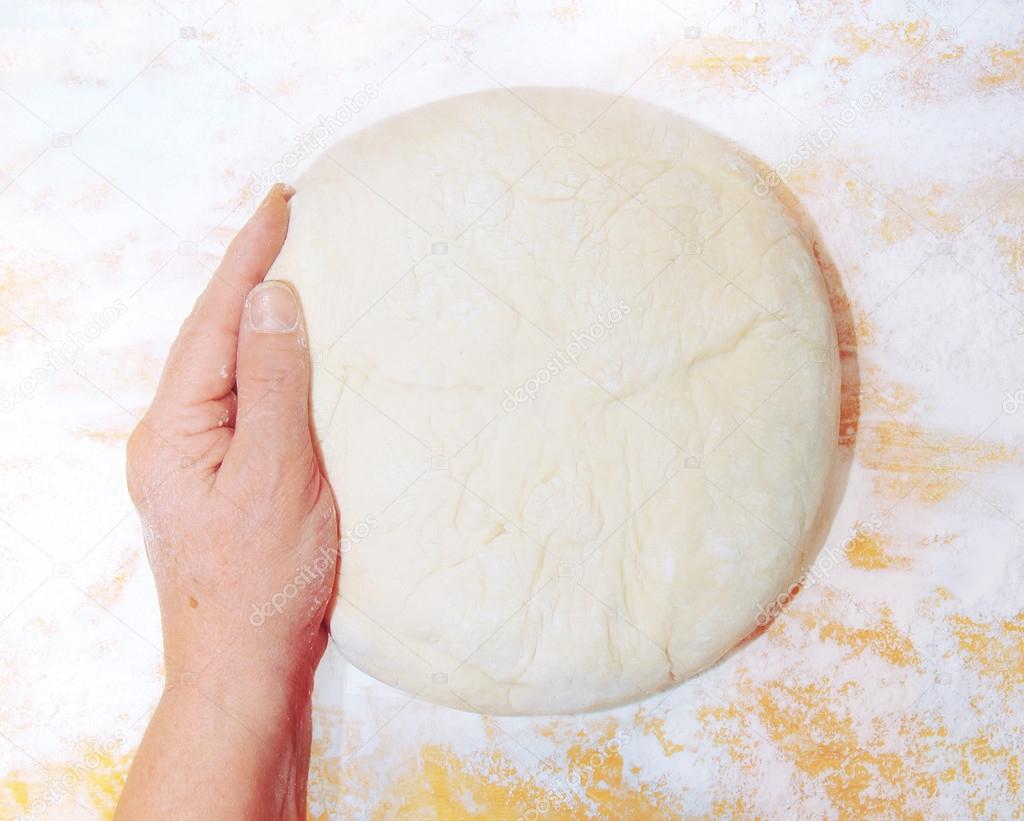 Women's hands knead the dough