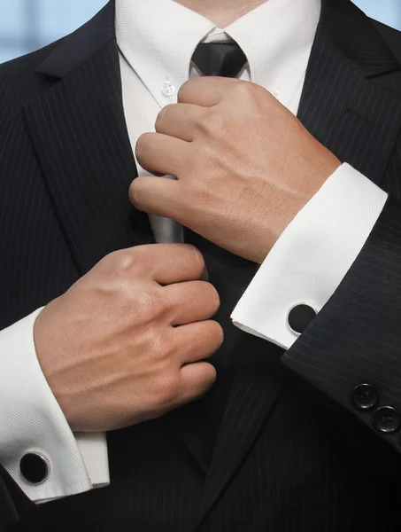 Man in a black suit straightens his tie — Stock Photo, Image