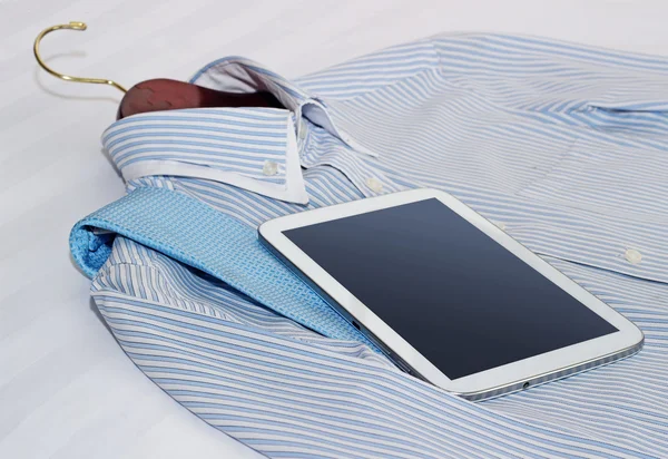Shirt en een tablet op het bed — Stockfoto
