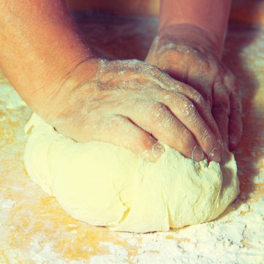 Kadınların elleri hamuru yoğurur.
