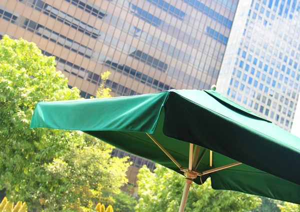 Sombrilla verde en un café en el centro de la ciudad — Foto de Stock