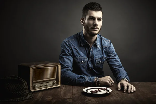 Portrait de jeune homme assis à une table, style vintage — Photo