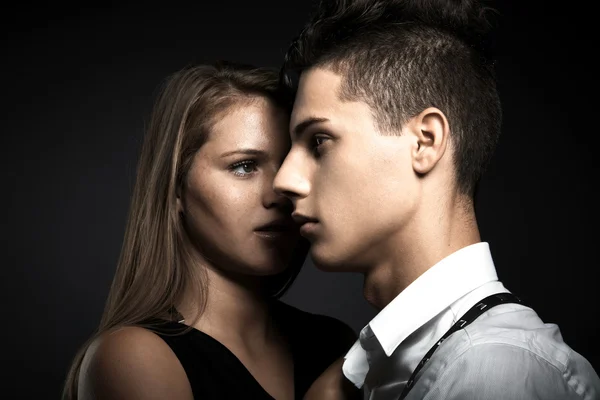 Portrait of fashion young couple against dark grey background — Stock Photo, Image