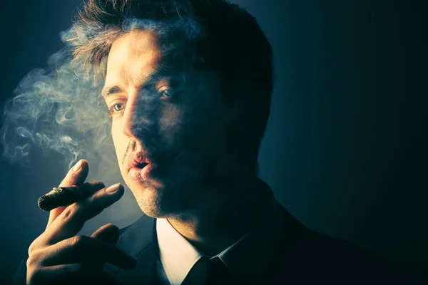 Handsome young man smoking cigar — Stock Photo, Image