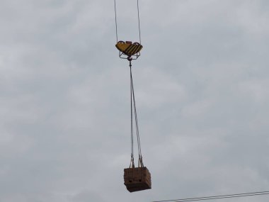 İnşaat alanında tuğla bir vinçle palet kaldırmak.