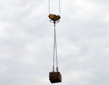 İnşaat alanında tuğla bir vinçle palet kaldırmak.