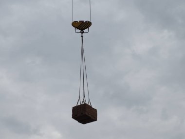 İnşaat alanında tuğla bir vinçle palet kaldırmak.