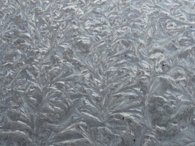 Bir kır evinin camında soğuk desenler var. 