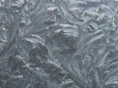 Bir kır evinin camında soğuk desenler var. 