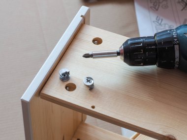 Tornavidalı bir masa için ahşap bir çekmece kurma işlemi.