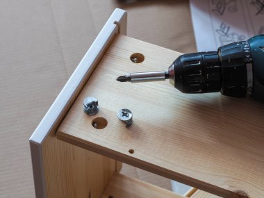 Tornavidalı bir masa için ahşap bir çekmece kurma işlemi.