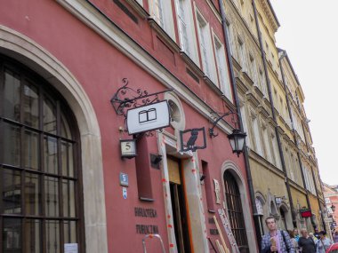 Geleneksel pembe ve beyaz dış görünüşlü dar bir sokak, kavisli bir pencere ve Eski Şehir 'in kalbinde iş ilanları.