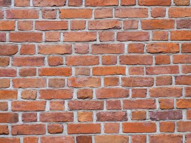 Yıpranmış eklemleri ve doğal aşınması olan tarihi kırmızı tuğla bir duvarın yakın çekim deseni..