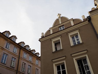 Parlak gökyüzüne karşı detaylı cepheleri olan geleneksel Avrupa konutlarının köşesine bakıyorum..