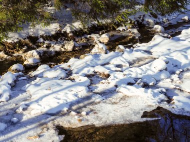 Kışın dağların eteklerinde eriyen kar ve buza yakın.
