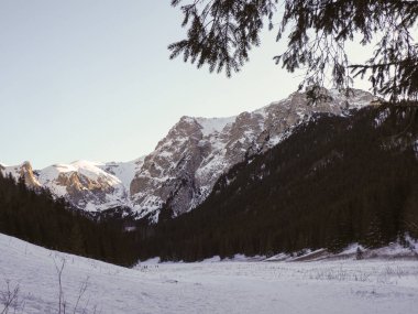Kış öğleden sonra açık gökyüzünün altında görkemli karlı dağ tepelerinin panoramik manzarası