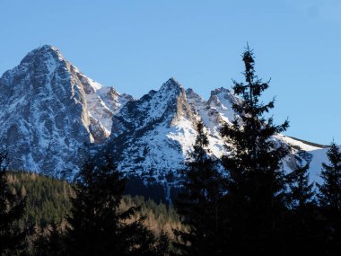 Keskin granit bir dağ sırtına yakın çekim açık mavi gökyüzünün altında kış günışığında.
