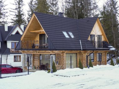 Kışın karanlık çatıları ve balkonları olan yeni dağ villaları.