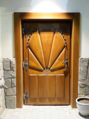 Radyal güneş patlaması desenli ve metal donanımlı geleneksel ahşap kapıyı kapatın.