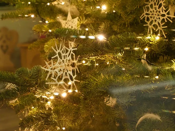 Noel ağacının dalında asılı beyaz bir kar tanesi süslemesi.