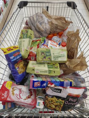 Çeşitli gıda ürünleri ve paketlerle dolu bir alışveriş arabasının üst görüntüsü