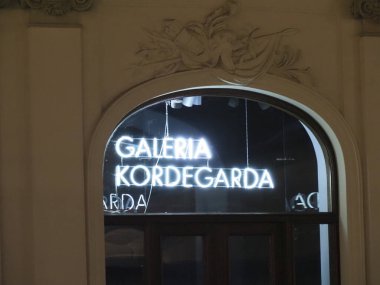 Varşova 'daki kemerli bir tarihi pencerenin altında parlayan Galeria Kordegarda tabelasına yaklaş