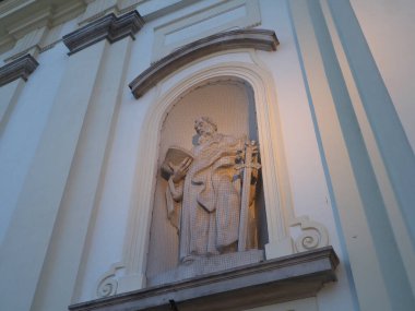 Dini heykelin alacakaranlıkta klasik mimari bir yere yerleştirilmiş düşük açılı görüntüsü.