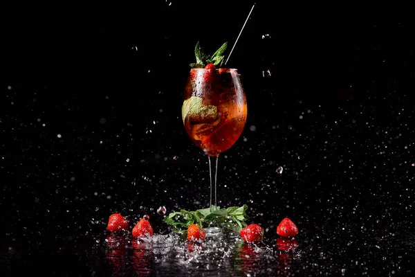 Cóctel sobre fondo negro con fresas menta en spray de agua — Foto de Stock