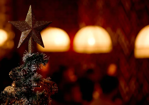 Yılbaşı yıldızı Noel ağacının tepesinde ve arka planda güzel bir tarafı var. — Stok fotoğraf