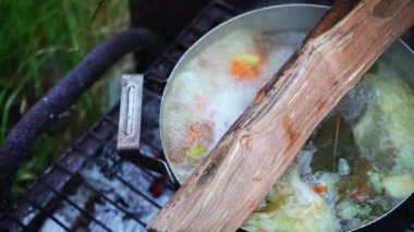 BBQ 'da kaynamış balık çorbası ile tavanın yakın çekimi, yavaş çekim. 