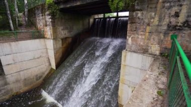 Bir şelale şelalesi ve eski baraj. Yaz manzarası. Yavaş çekim.