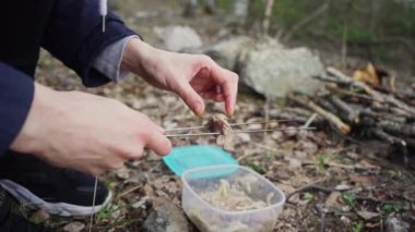Küçük keskin kamp bıçağı yanan bir şenlik ateşinin önünde bir taşın üzerinde yatıyor. Yavaş çekim görüntüleri.