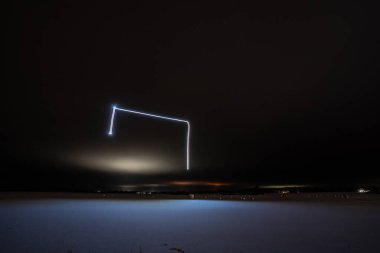 Gece vakti kış şehrinin üzerinde parlak bir aydınlık 