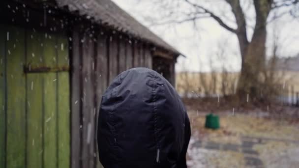 Kapüşonlu Erkek Başının Üzerine Yağan Dolu Görüntüleri Bulanık Köy Evi — Stok video