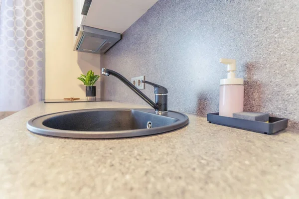 Küçük açık mutfağı olan gri ve beyaz daire detayları.